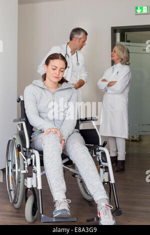 Patient en fauteuil roulant, les médecins dans la discussion historique Banque D'Images