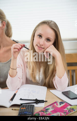 Portrait of teenage girl doing homework, smiling Banque D'Images