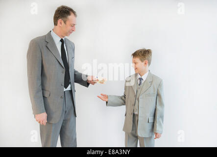 Père de remettre de l'argent à son fils, smiling Banque D'Images