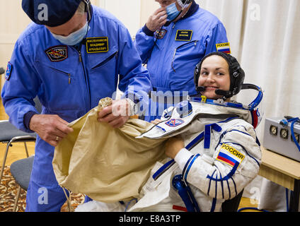Expedition 41 Elena Serova ingénieur de vol de l'Agence spatiale fédérale russe (Roskosmos) est aidé dans sa combinaison Sokol Russe Banque D'Images