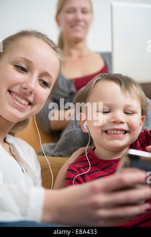 Soeur listening to mp3 player avec son frère, smiling Banque D'Images