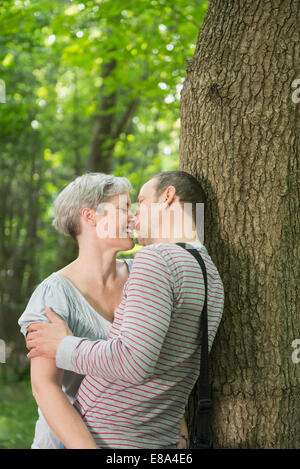 Mature couple kissing in forest Banque D'Images