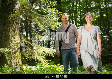 Portrait of mature couple walking in forest, smiling Banque D'Images