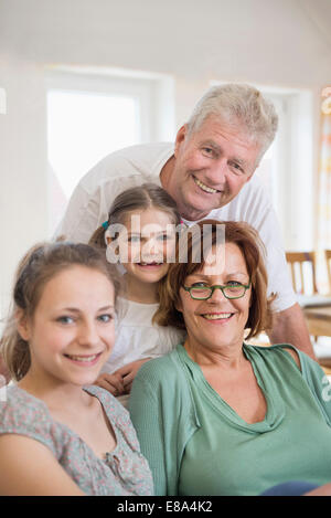 Portrait des grands-parents et des petites-filles dans la salle de séjour, smiling Banque D'Images