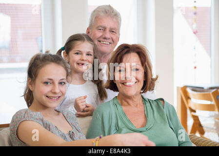 Portrait des grands-parents et des petites-filles dans la salle de séjour, smiling Banque D'Images