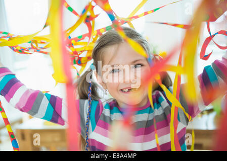 Portrait of Girl with blowout paper streamer at Birthday party, smiling Banque D'Images