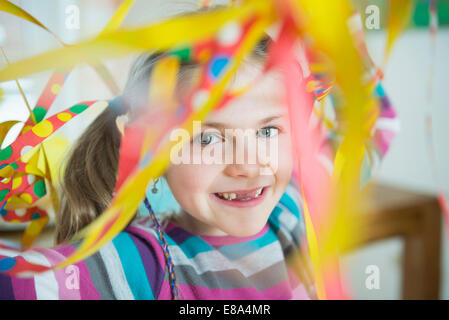 Portrait of Girl with blowout paper streamer at Birthday party, smiling Banque D'Images