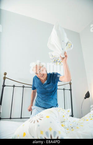 Portrait of young pillow fight, smiling Banque D'Images