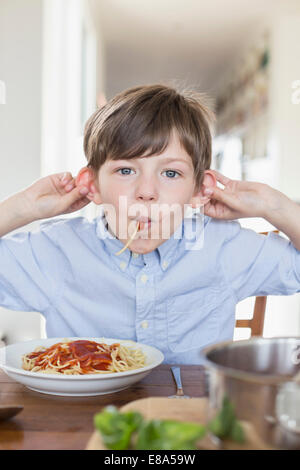 Boy eating spaghetti Banque D'Images