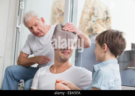 Grand-père, père et fils de jouer avec cap Banque D'Images