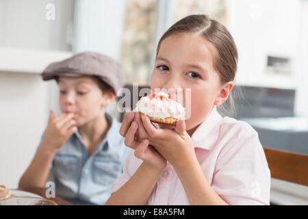 Brunette girl eating cake, portrait Banque D'Images