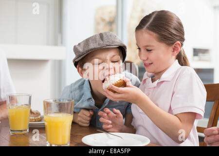 Frère et sœur espiègle eating cake Banque D'Images