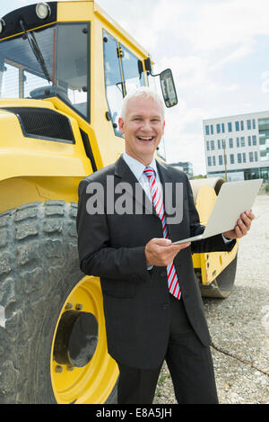 homme d'affaires avec ordinateur portable sur le chantier de construction Banque D'Images