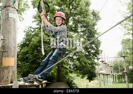 Boy climbing crag, smiling Banque D'Images