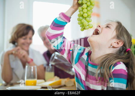 Les grands-parents et petite-fille, souriant having meal Banque D'Images