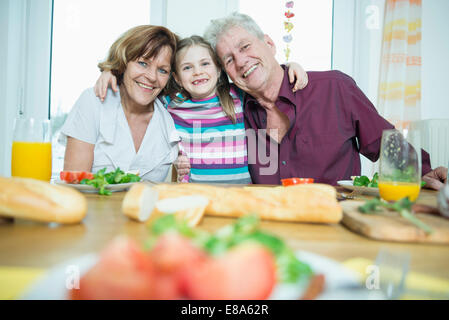 Portrait des grands-parents et petite-fille, souriant having meal Banque D'Images