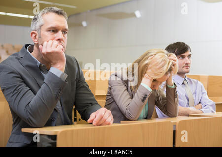 Ennuyer businesspeople sitting in auditorium Banque D'Images