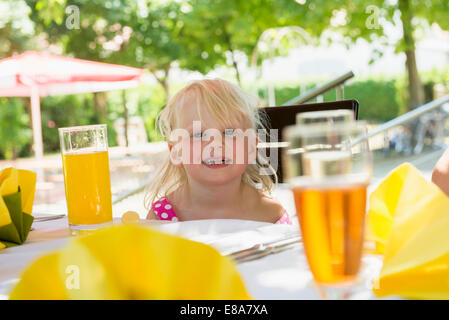 Petite fille assise à table Banque D'Images