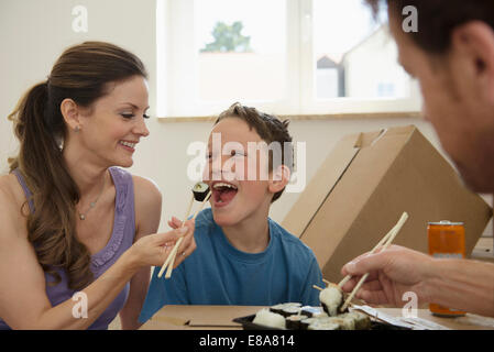 Nouvelle maison déménagement dans family eating sushi Banque D'Images