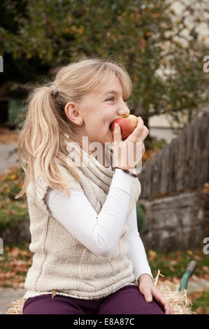 Blonde girl eating an apple Banque D'Images