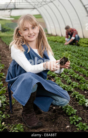 Smiling blonde girl in greenhouse Banque D'Images