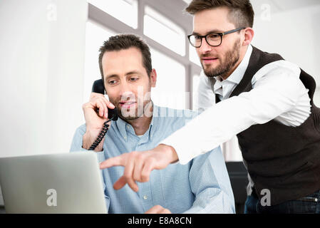 Deux hommes parlant téléphone réunion informatique Banque D'Images