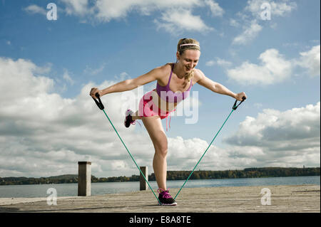 Woman Woman exercising with resistance band, Woerthsee, Bavière, Allemagne Banque D'Images