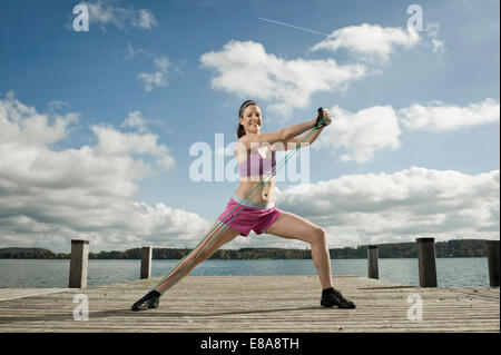 Woman Woman exercising with resistance band, Woerthsee, Bavière, Allemagne Banque D'Images