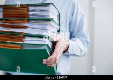 Close up man carrying pile de dossiers de dépôt Banque D'Images