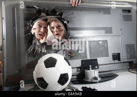 Deux adolescents regardant choqué ballon de soccer démolir plat Banque D'Images