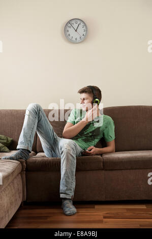 Teenage boy listening music at home Banque D'Images