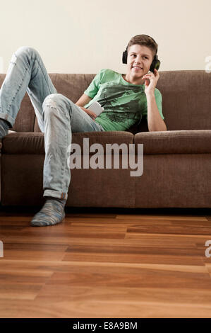 Teenage boy listening music at home Banque D'Images