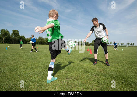 Entraîneur de soccer player aider à enseigner à de jeunes Banque D'Images