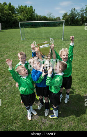 Les jeunes garçons de l'équipe de soccer holding trophy Banque D'Images