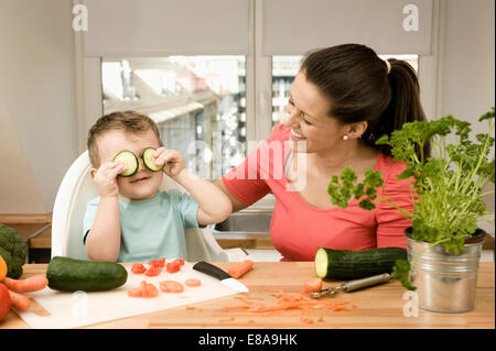 La mère et le fils de la préparation de légumes dans la cuisine, smiling Banque D'Images