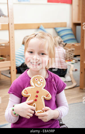 Smiling little girl holding Gingerbread Man Banque D'Images