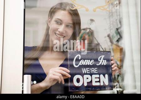 Sales girl holding commission d'ouverture de boutique de mode, smiling Banque D'Images