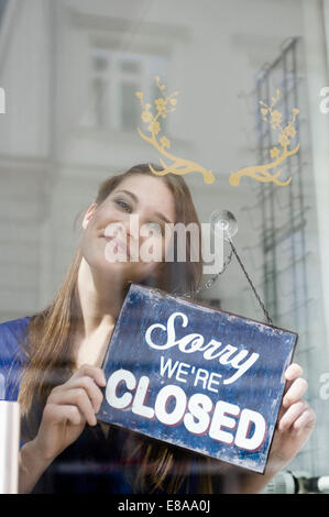 Portrait of Girl holding vente conseil d'clôture boutique de mode, smiling Banque D'Images