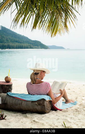 Femme lisant un livre sur la plage, Koh Lipe, Thaïlande Banque D'Images