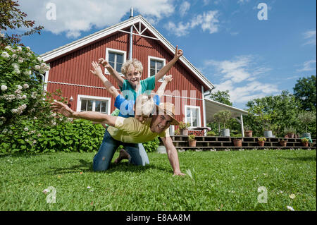 Père et fils playing in garden house Banque D'Images