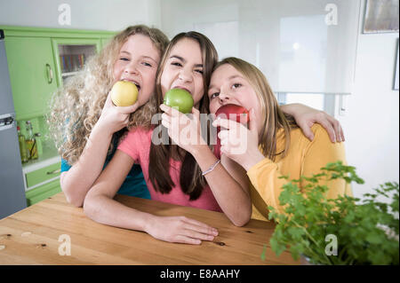 Les filles dans la cuisine manger des pommes Banque D'Images