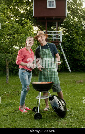 Jeune couple barbecue jardin de la bière Banque D'Images