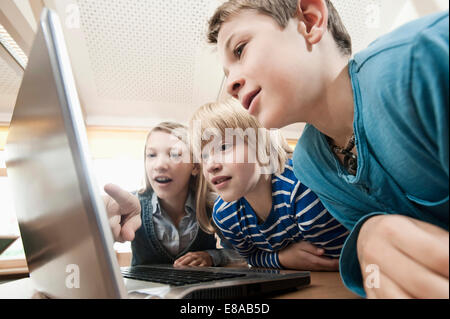 Trois enfants looking at laptop Banque D'Images