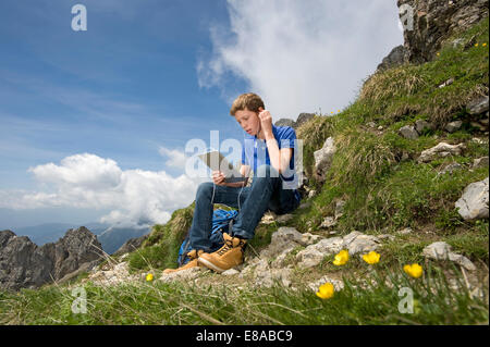 Teenage boy en utilisant l'iPad en mode paysage de montagne Banque D'Images