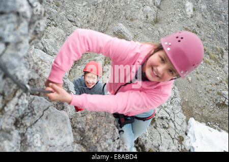 Boy girl climbing rock face Alpes