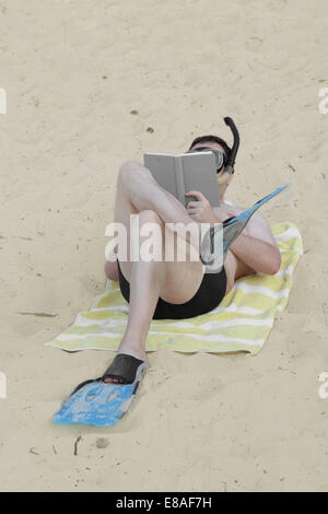 L'homme à palmes et masque de plongée avec tuba jette sur le sable et lit d'adresses Banque D'Images