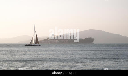 L'île d'Alcatraz prison dans la brume d'un bateau de course qui passe Banque D'Images