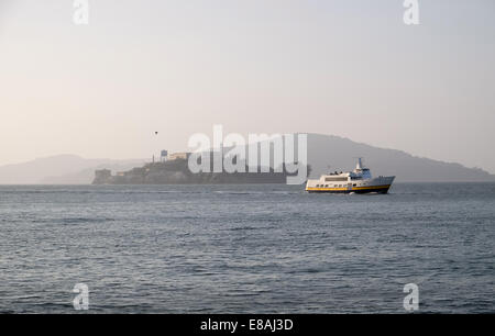 L'île d'Alcatraz prison dans la brume avec un bateau d'excursion à l'avant-plan Banque D'Images