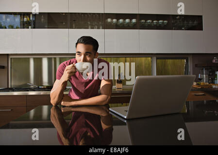 Jeune homme dans la salle à manger boire du café Banque D'Images