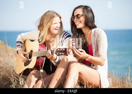 Deux jeunes femmes avec la guitare acoustique à l'autre, Malibu, California, USA Banque D'Images